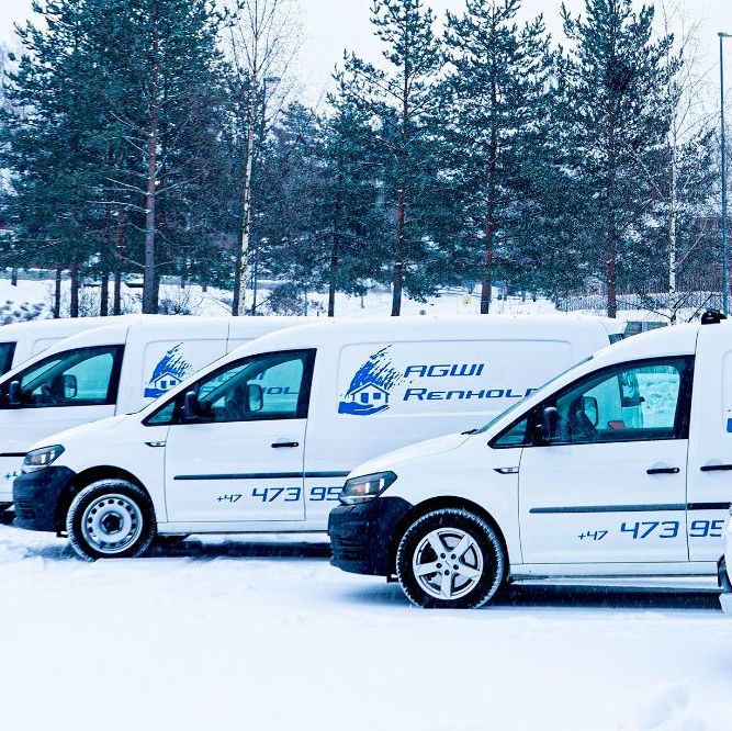 Mann måker snø med skianlegg i bakgrunnen