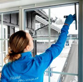 Kvinne rengjør vindu på hytte