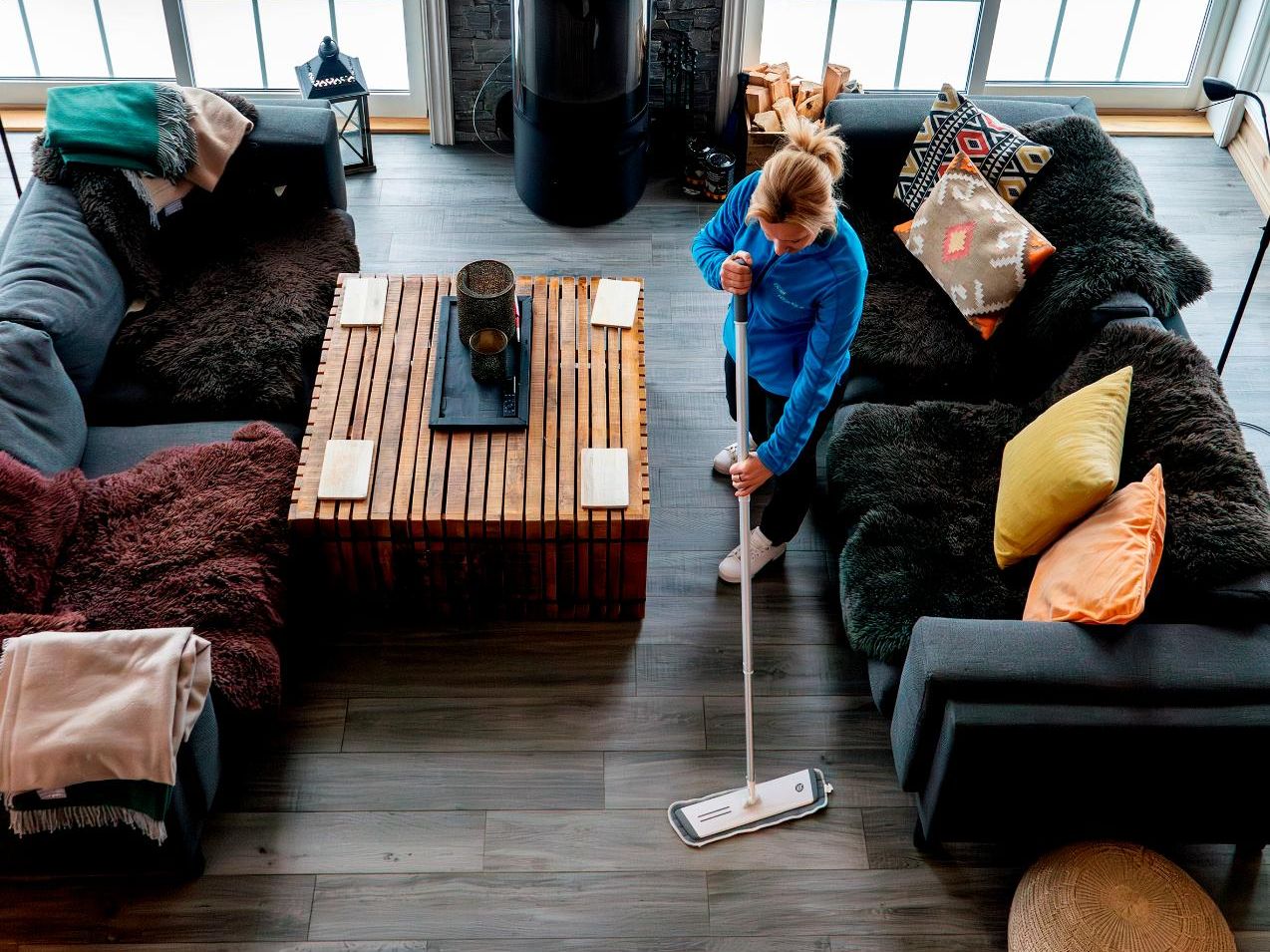 Kvinne rengjør gulv med mopp
